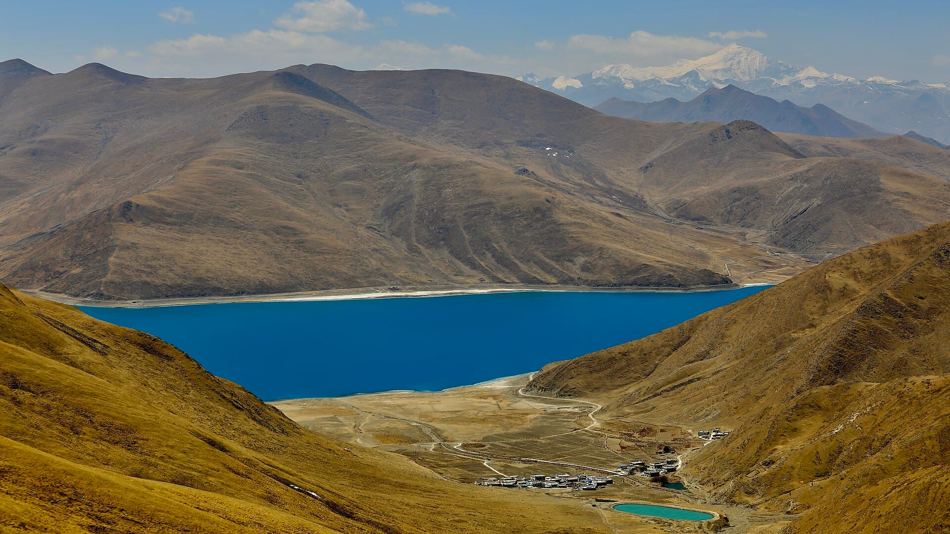 The turquoise water of Yamdrok Lake between bare hills